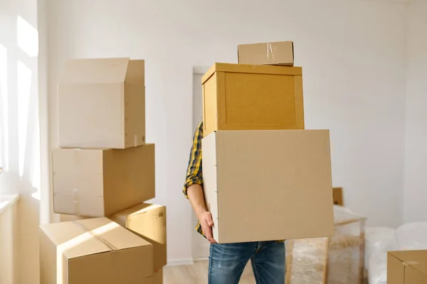 Człowiek niosący wiele kartonowych pudełek w stosie — Zdjęcie stockowe