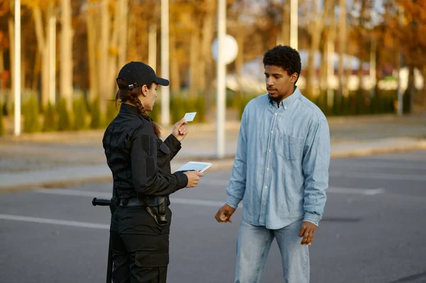 Poliziotto donna che controlla il documento d'identità del passante maschio — Foto Stock