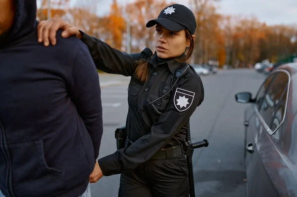 Politievrouw arresteert man autodief op de weg — Stockfoto