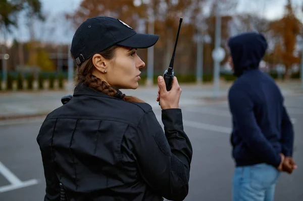 Woman cop using portable radio back view — Stock Photo, Image