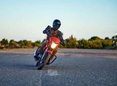 Student riding on motordrome in motorcycle school clipart