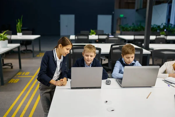 Los niños que trabajan en el ordenador portátil en la oficina moderna —  Fotos de Stock