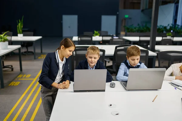 Los niños que trabajan en el ordenador portátil en la oficina moderna — Foto de Stock