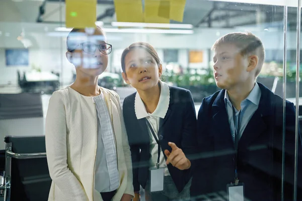 Equipo de negocios de niños hablando en el tablero de vidrio — Foto de Stock