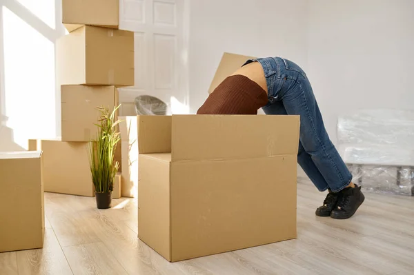 Funny woman looking something in big box — Stock Photo, Image