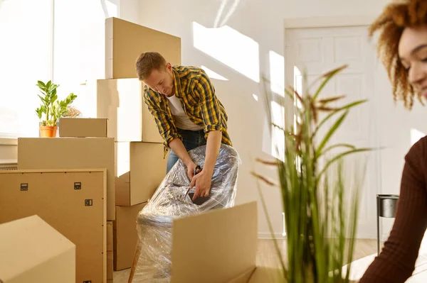 Smiling couple unpacking furniture in new home — Stock Photo, Image