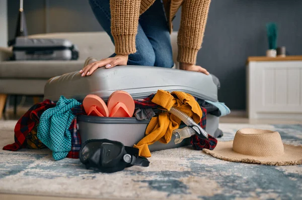 Woman trying to close overload travel suitcase — Stock Photo, Image