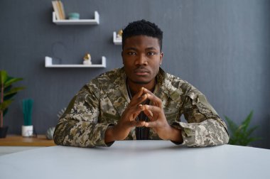 Hüzünlü asker kamera portresine bakıyor.