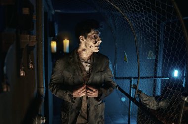 İş elbisesi giymiş ürkütücü zombi adam yürüyor.