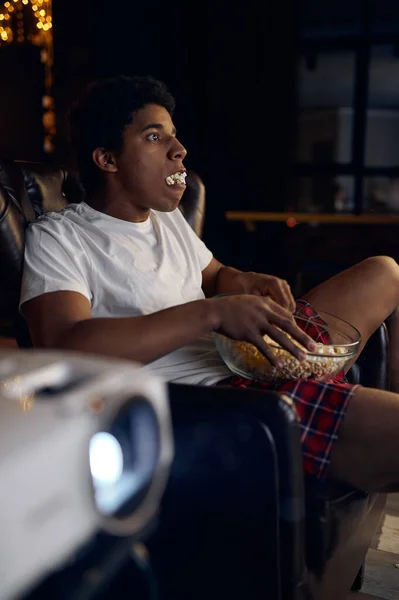 Guy with bowl of popcorn watching movie — Stock Photo, Image