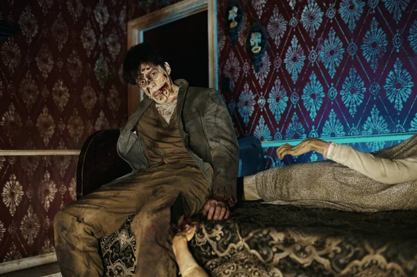 Зомбі сидить на ліжку, дивлячись на камеру — стокове фото