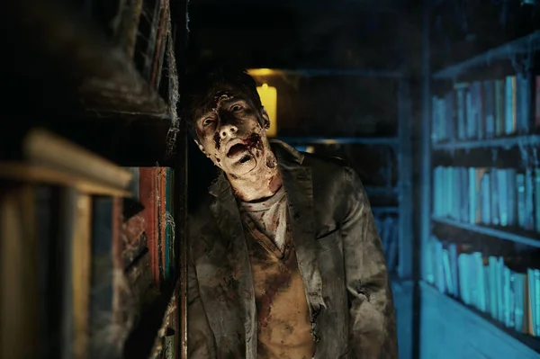 Зомбі чоловік у покинутій бібліотеці — стокове фото