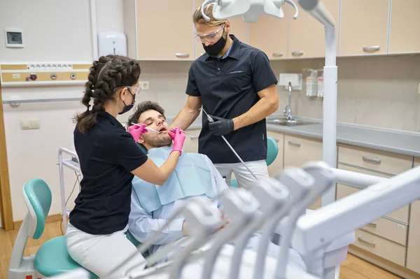 牙科医生在牙科诊所治疗男性病人 — 图库照片