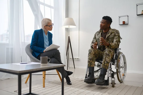 Tolószékes mozgássérült katona terapeutával beszélget. — Stock Fotó
