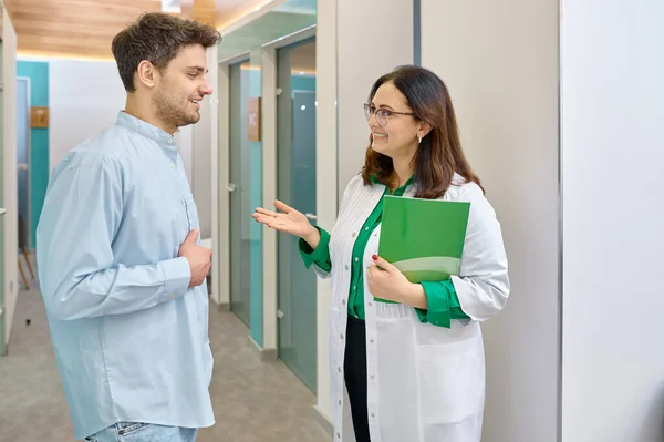 Doctora discutiendo algo con paciente masculino — Foto de Stock