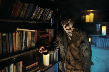 Terk edilmiş kütüphanedeki zombi adam portresi