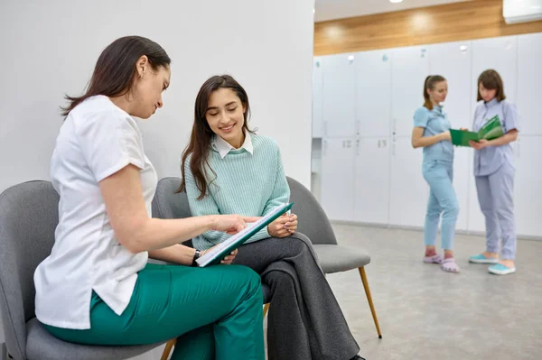 Doctor talking to teen patient in hallway — Stock Photo, Image