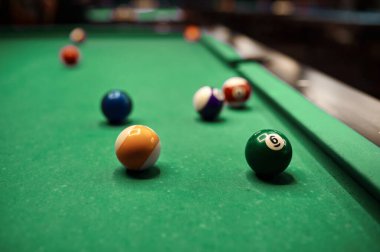 Yeşil bilardo masasında farklı bilardo topları. Seçici odak, yüzeysel alan derinliği
