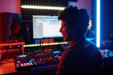 Kayıt stüdyosunda ya da radyo istasyonunda geceleri çalışan mutlu gülümseyen müzik yapımcısı.