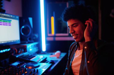 Gece kayıt stüdyosunda ya da radyo istasyonunda çalışan müzik yapımcılarının kulaklıkla yeni şarkılar dinlemesine sevindim.