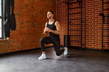 Spor salonunda çömelme egzersizi yapan kaslı, sportif bir adam. Hareket, hareket, gençlik, sağlıklı yaşam tarzı konsepti