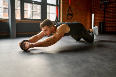 Spor kulübü spor salonunda çıplak karın kaslarıyla antrenman yapan bir adam. Sağlıklı yaşam tarzı ve egzersiz konsepti