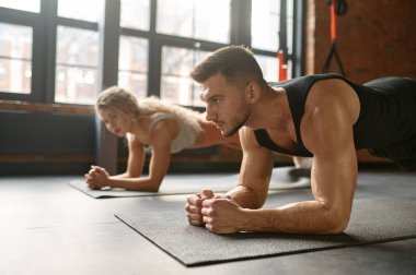 Erkek ve kadın tahtanın üzerinde durur. Spor kulübü beden eğitimi dersinde grup çalışması. Sporcuya odaklan. Spor konsepti