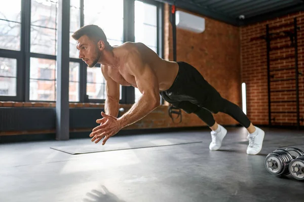 Sportsman doing clapping push-ups exercise at gym sport club. Explosive strength training, crossfit fitness workout and strenght power concept