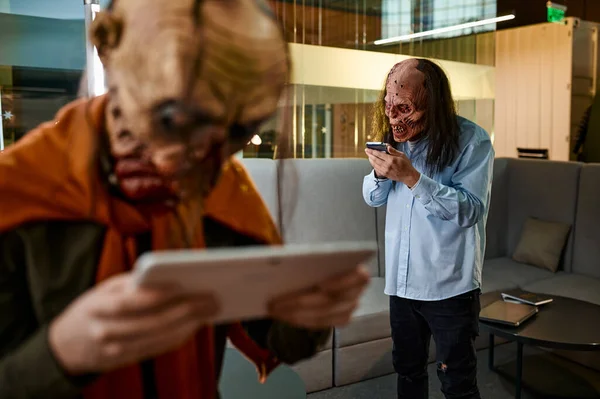 Ugly zombie people using digital device in office. Social media network, gadget addiction concept