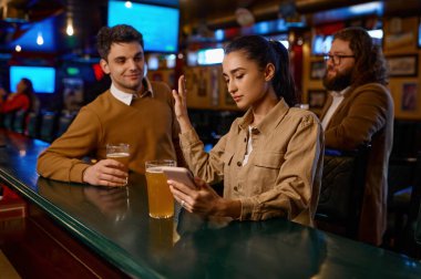 Akıllı telefon kullanan genç bir kadın bar tezgahında oturuyor ve erkeği reddediyor. İlgisiz buluşma, başarısız flört konsepti