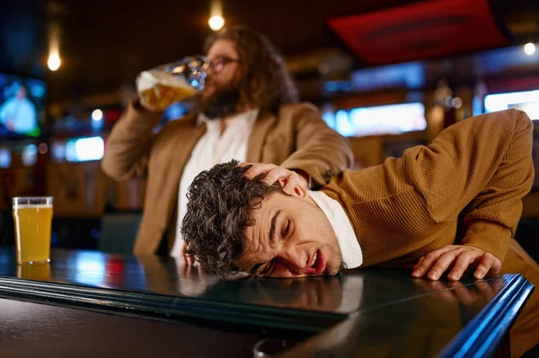 足球迷在体育酒吧的疯狂行为 男人拉着别人的脸在吧台柜台边喝啤酒 — 图库照片