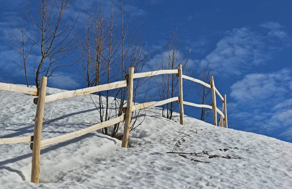 Drewniane Ogrodzenie Śniegu Pod Błękitnym Niebem — Zdjęcie stockowe