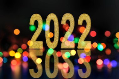 2022 ve siyah arkaplanda bulanık çok renkli ışık yansıması 