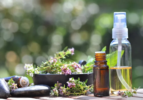 Flaschen Mit Ätherischem Und Blüten Aromatischer Kräuter Auf Einem Tisch Stockbild