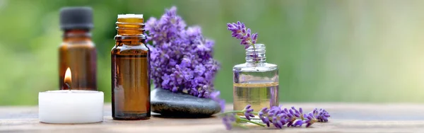 Bottles Essential Oil Lavender Flowers Arranged Wooden Table Canddle Pebble — Stock Photo, Image