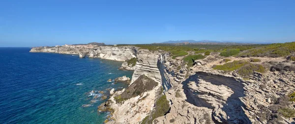 澄んだ青い空に海を見下ろす石灰岩の崖とボニファシオコルシカ島の海岸線 — ストック写真
