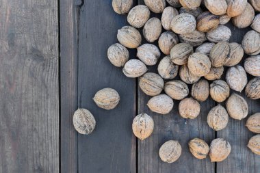 top view on walnuts in their shell spread on a plank  