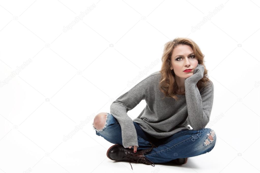 Beautiful blond woman sitting on floor
