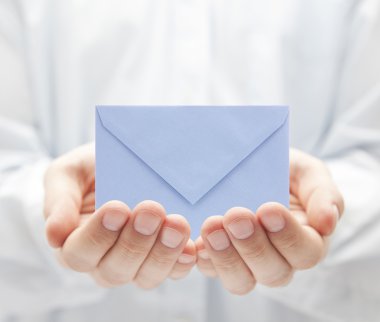 Blue paper envelope in hands clipart