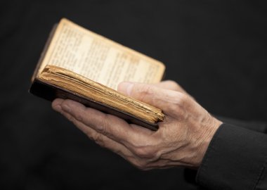 yaşlı bir adam kitap tutan eller