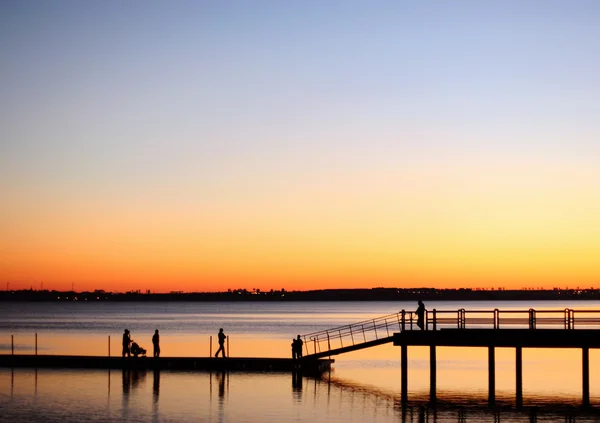 Weergave van het silhouet lopen op een pier — Stockfoto