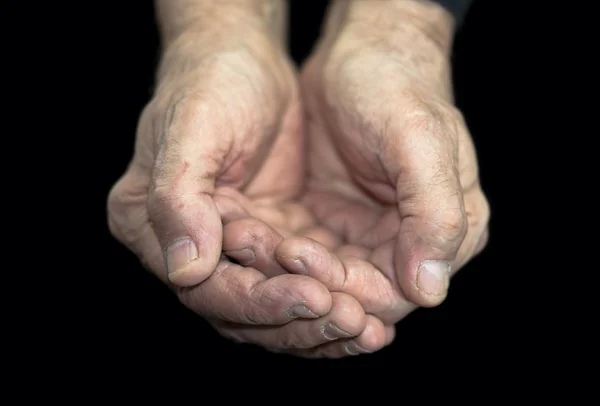 La pauvreté. Vieilles mains sur noir avec chemin de coupe — Photo