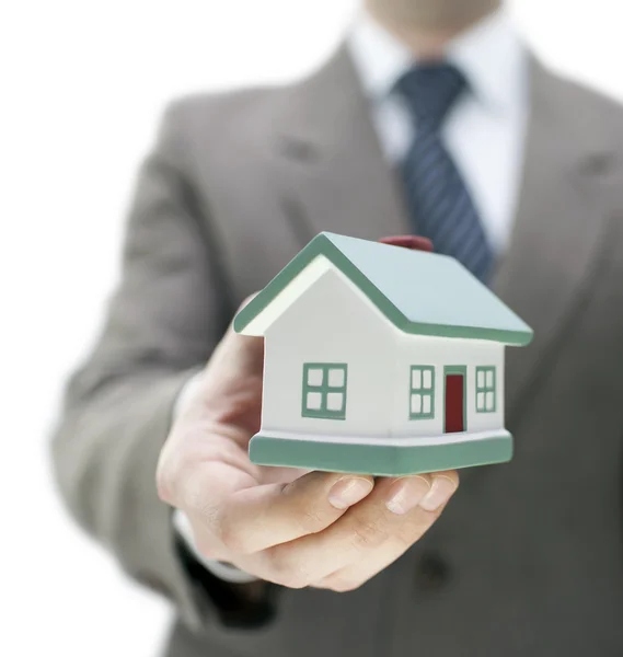 Real estate agent holding a toy house — Stock Photo, Image