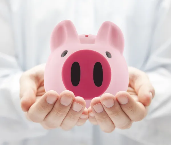 Hombre sosteniendo gran alcancía rosa — Foto de Stock