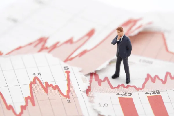Financiële crisis. figuur van zakenman op financiële grafieken — Stockfoto