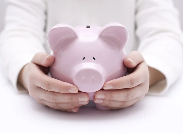 Piggy bank beschermd door handen — Stockfoto