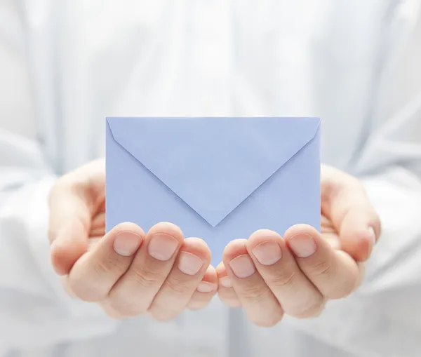 Envelope de papel azul nas mãos Fotografia De Stock