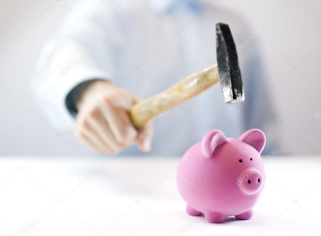 Pink piggy bank and hand with hammer