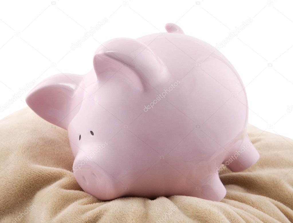 Piggy bank lying down on a pillow.