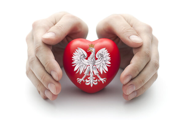 Hands covering Polish coat of arms on a red heart
